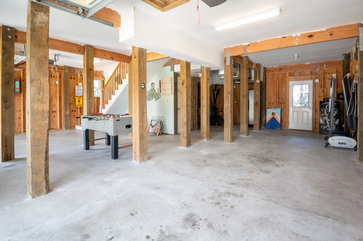 A bright recreational space featuring exposed wooden beams, a foosball table, and a staircase. The mood is energetic and playful, ideal for socializing and friendly competition.